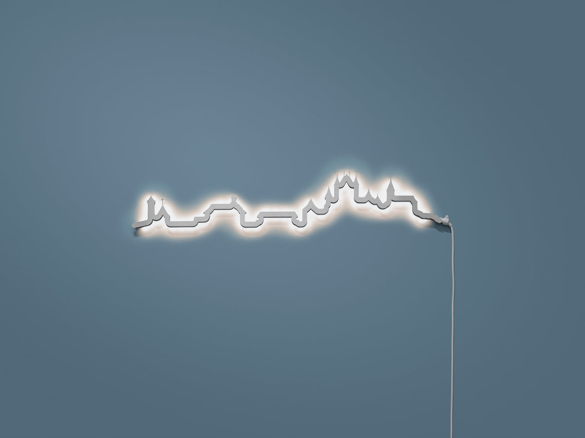 Kontura Skyline Mini Thun in Chromstahl, beleuchtet an der Wand #Farbe_Chromstahl